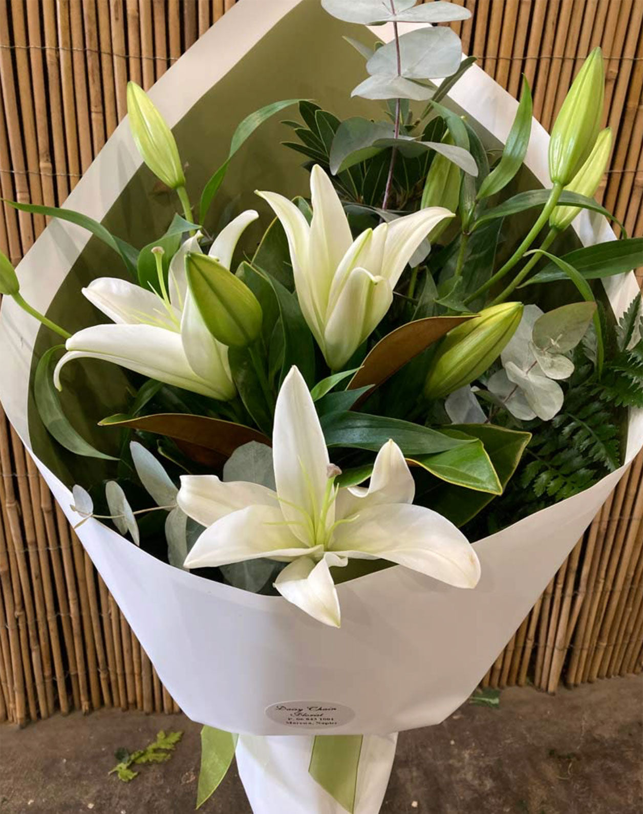 A bouquet of white oriental lilies with green foliage, gift wrapped with a bow, Hawke's Bay florist, Daisy Chain Florist, bloom, Madisons