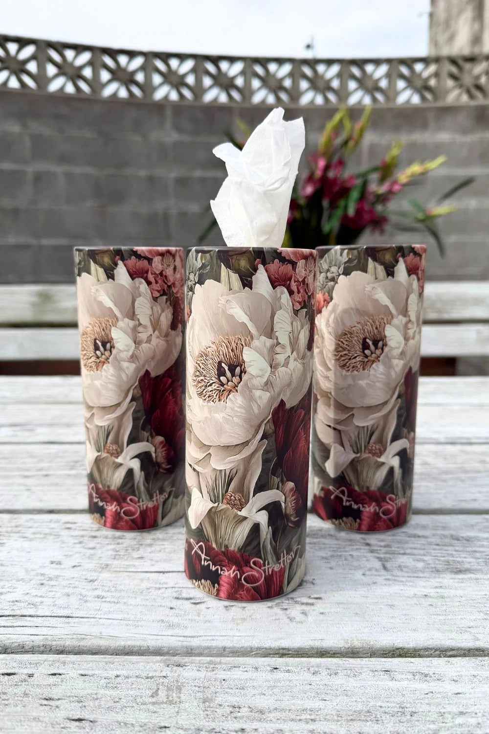 Three floral refillable tissue cylinders in the Adorable print standing side by side