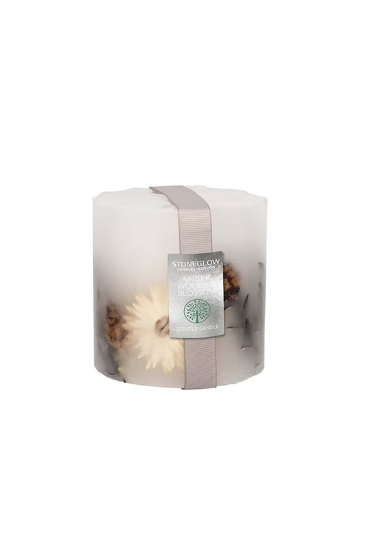 Candle with floral elements with a label on a white background
