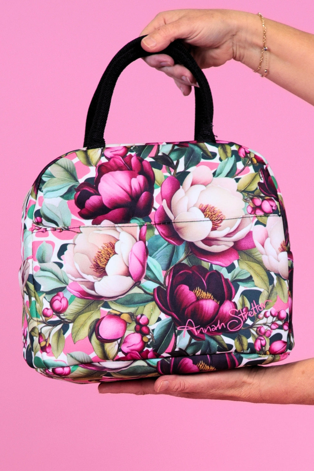 Annah Stretton Crimson Grace insulated cosmetic and travel bag held by the double top handles